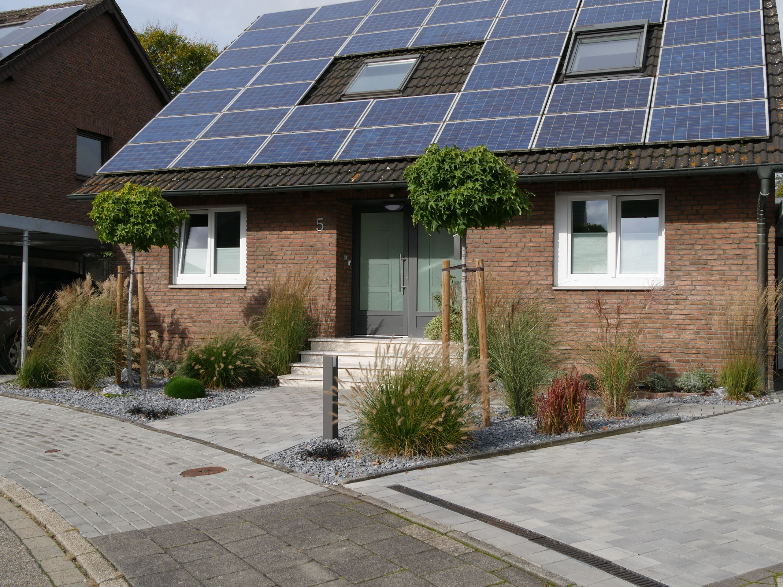 Vorgarten mit Splittbeet und Graesern